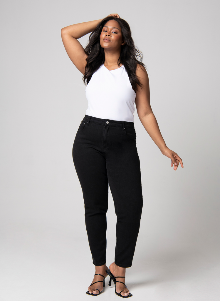 Model wears black Mom Jeans and white tank top, with heels.