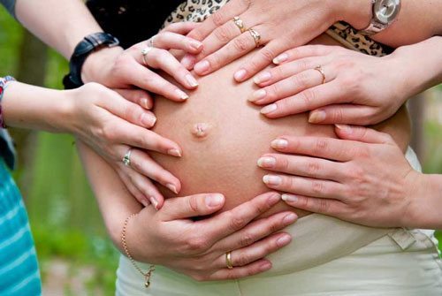 7-things-you-need-to-know-about-the-second-trimester-people-touching-belly