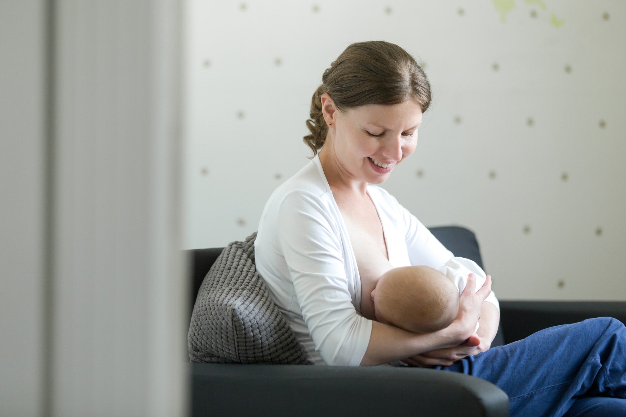 A woman wearing a maternity bra and nursing her child