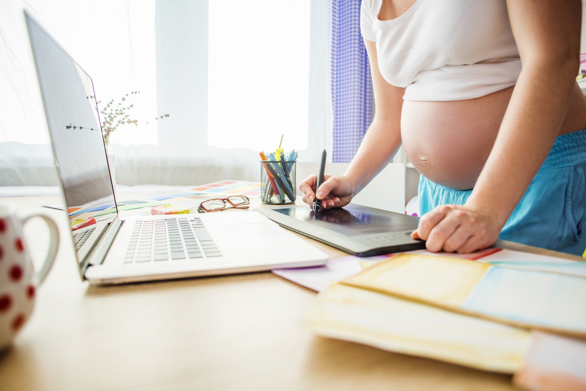 Pregnant woman working on a postpartum kit list.