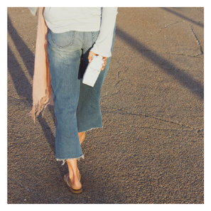 lady walking with cut off jeans and pink scarf with everybody water