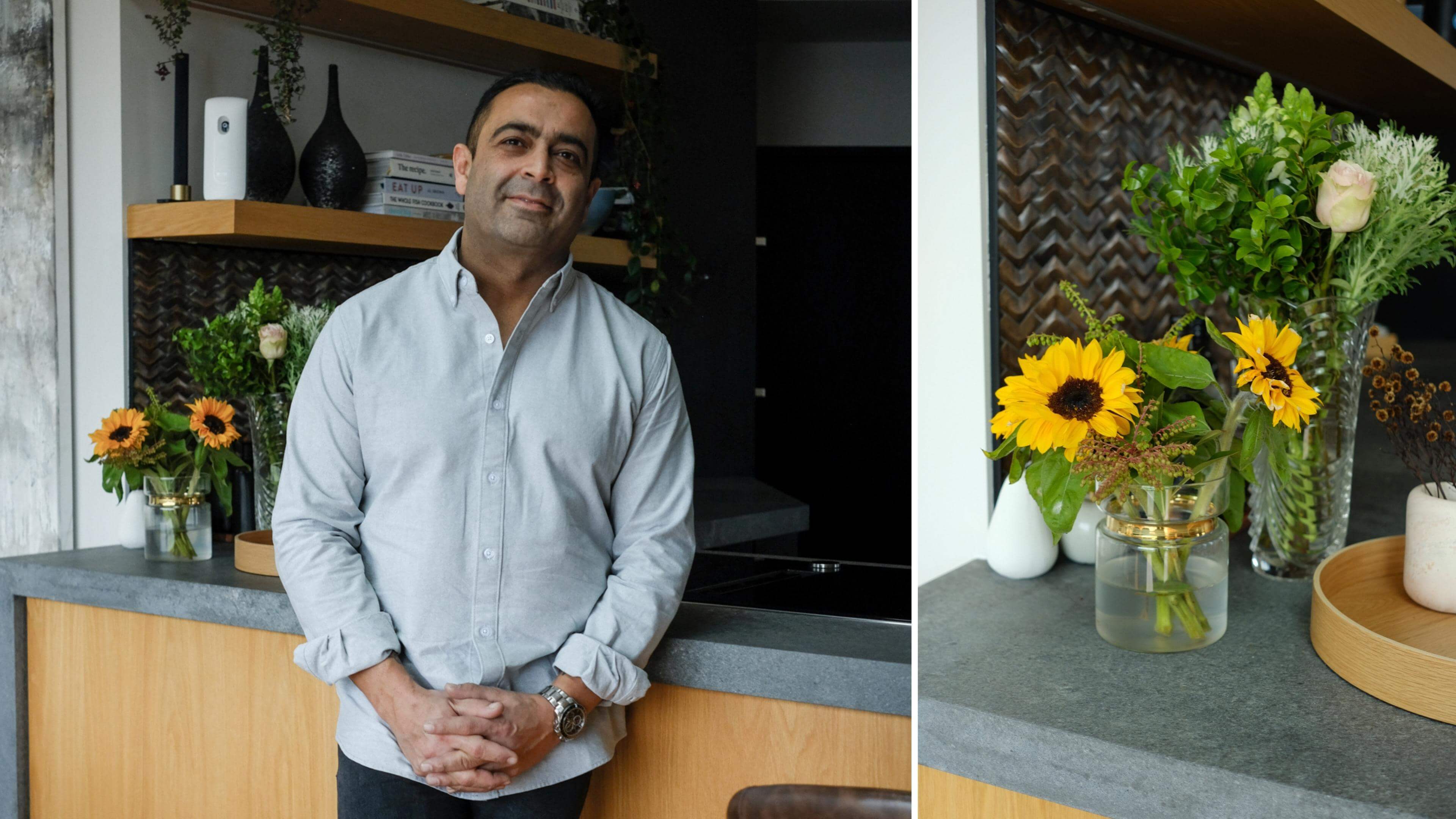 Sid Sahrawat Chef standing in front of his kitchen next to an image of some flowers on the countertop