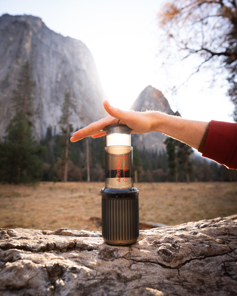 Aero Press coffee maker near a mountain