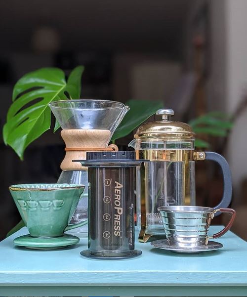 An older model of AeroPress amongst other coffee makers