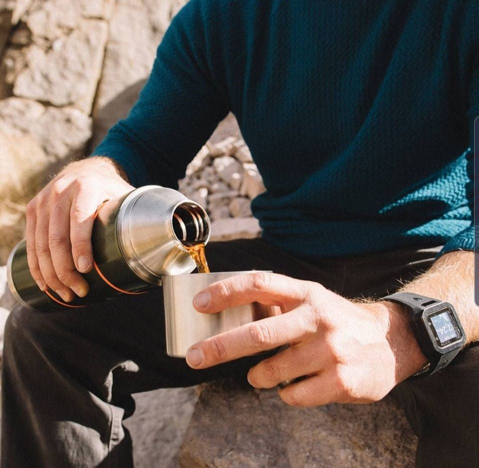 man pouring coffee from a flask