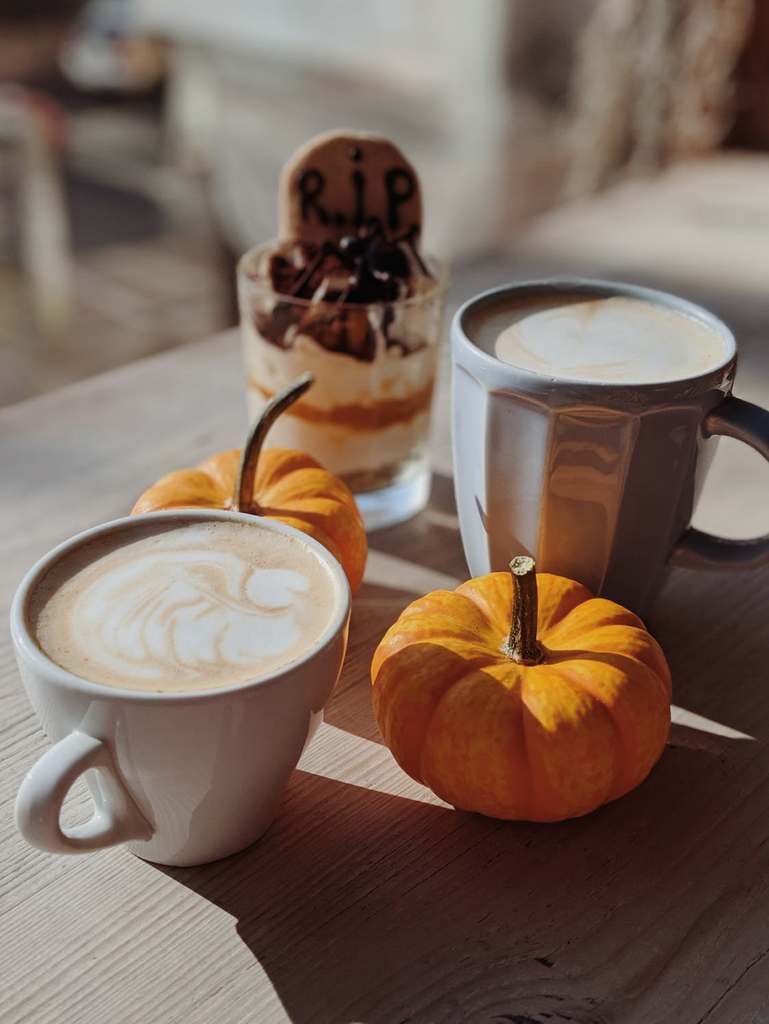 cup of coffee next to a pumpkin