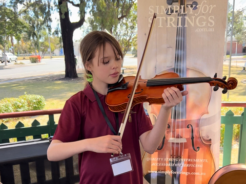 A young Millmerran girl playing a violin donated by Simply for Strings