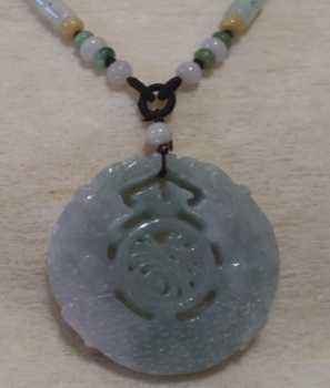 This dark piece of jade is emulating two dragons in a round form