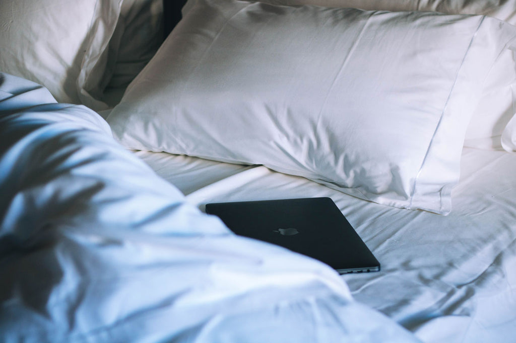 Laptop in unmade bed