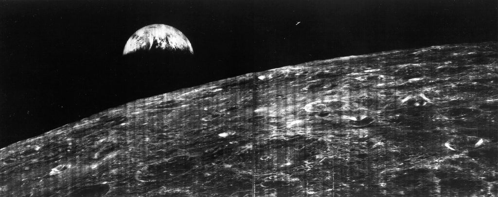 Black and white photo of the surface of the moon with the Earth seen in the background. - History By Mail