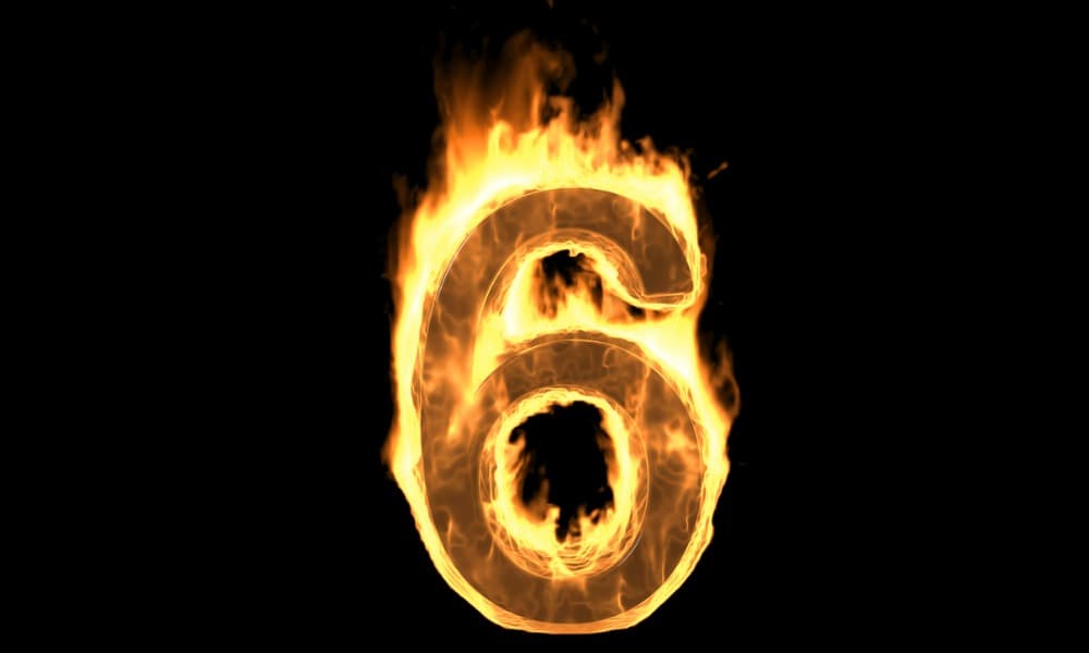 A number six on fire against a dark background representing six risk factors for cheap grills.