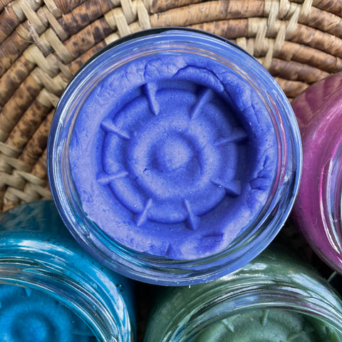 vibrant purple playdough with a round playdough stamp on a woven playdough placement