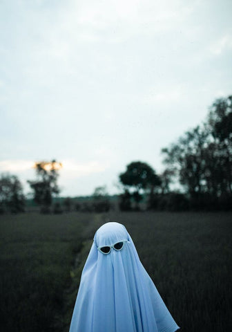 child dressed as a ghost wearing a sheet for halloween