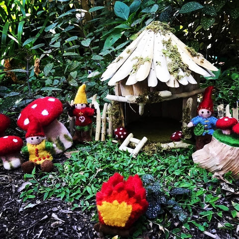 Beautiful felt and wooden toys by Papoose toys in a garden setting. The felt toadstools, log fire, toadstool tree stumps, and hand felted garden gnomes look right at home in this garden. You can use felt and wooden toys to make a fairy garden outside.