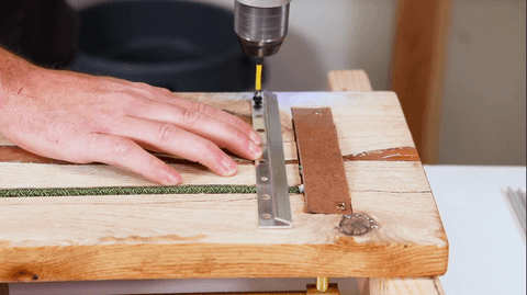 Hand drilling metal hinge onto wood board