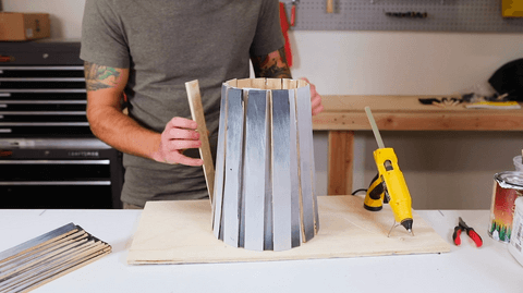 Person putting together a wood structure in a woodworking studio