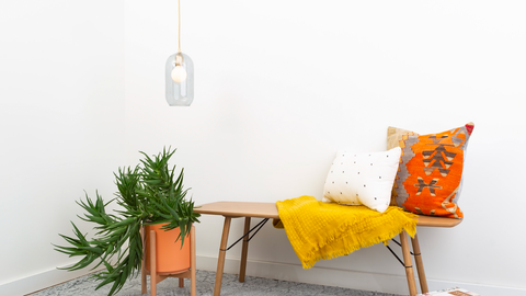 clear glass pendant light shade over a bench