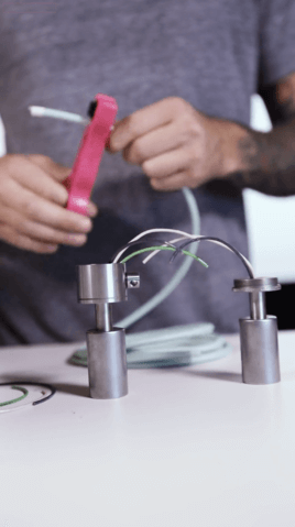 Man holding white electrical cord and wire cutters