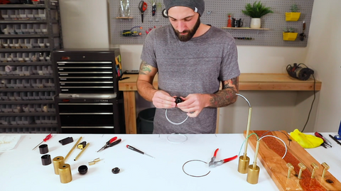 Man with electrical parts standing at workbench