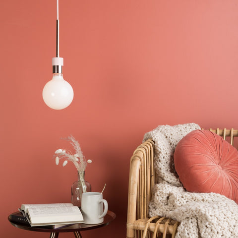 pendant light with naked bulb above a reading nook