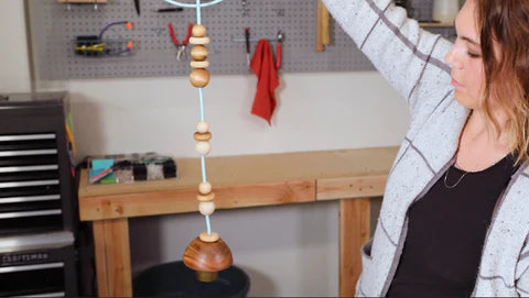 woman holding a beaded light fixture