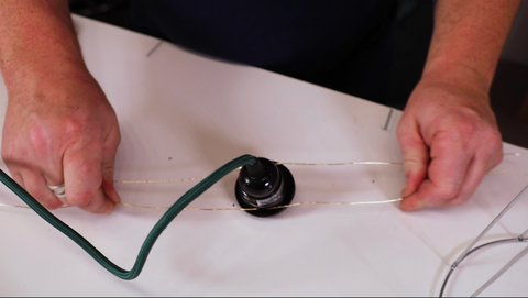 A man wrapping the sturdy wire around the socket