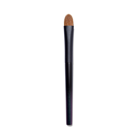 Full view of the Surratt Perfectionniste Complexion brush. The handle is black with subtle purple shimmer. The natural bristles are brown and in a soft curved taper.