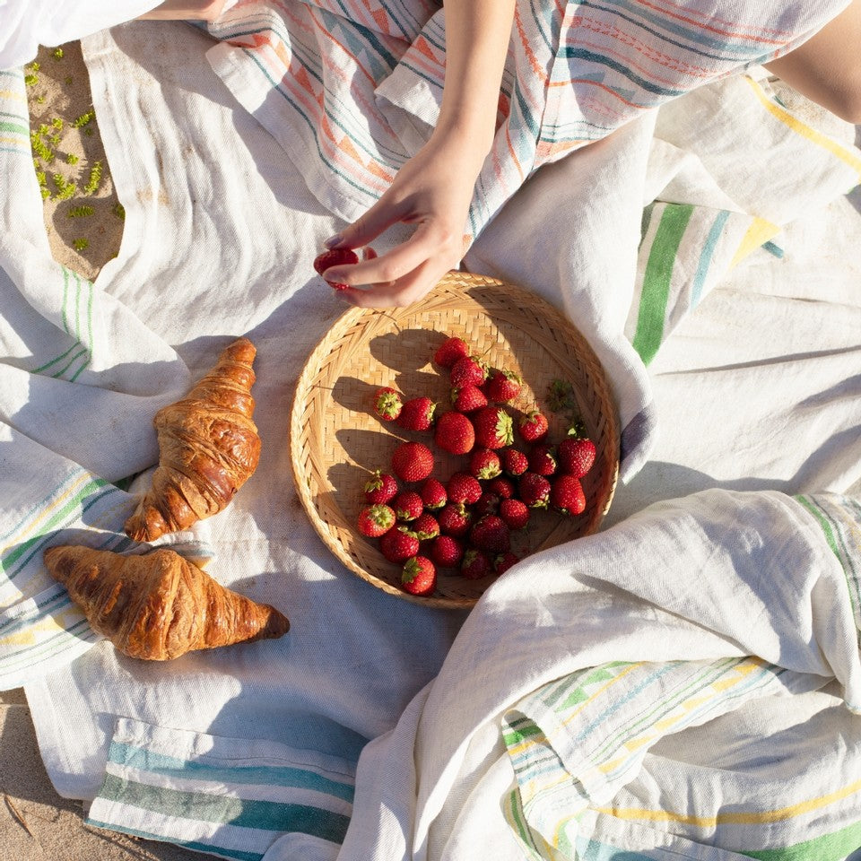 Picnic scene with Lapuan Kankurit textiles with bowl of raspberries and croissants