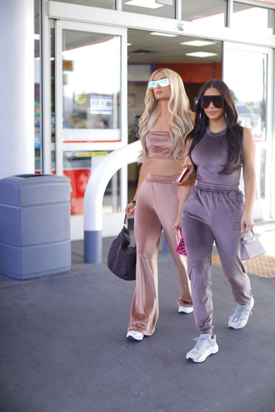 Paris Hilton and Kim Kardashian walking on the streets wearing SKIMS velour tracksuits.