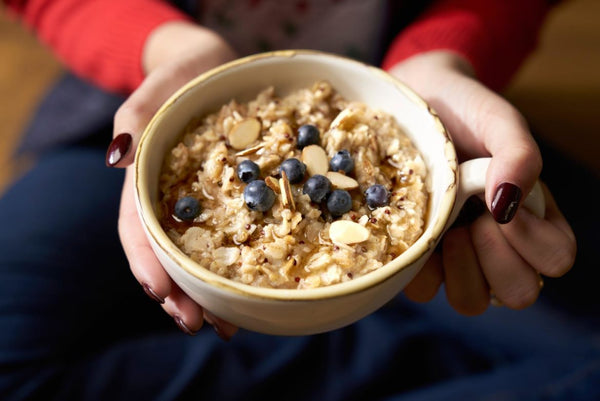 a cup of oatmeal with blueberries and pecans