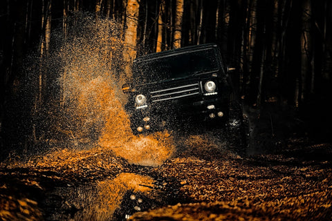 A jeep splashing water in the woods, shielded by paint protection film and coating