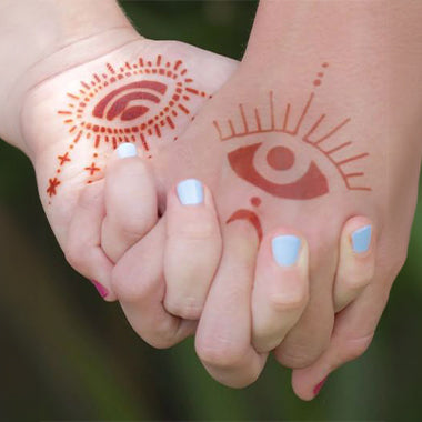 Two people holding hands adorning starry eyes henna tattoo design.