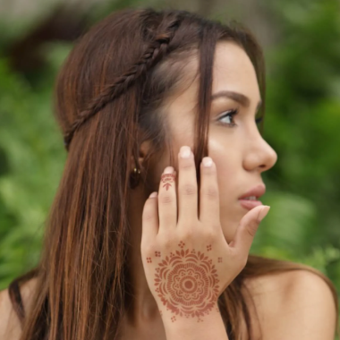 Women with mandala henna tattoo on the back of the hand