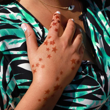Stellar Star henna tattoo on the back of a woman's hand