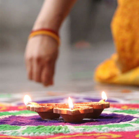 Creating a Rangoli for Diwali with Diya lights in the center