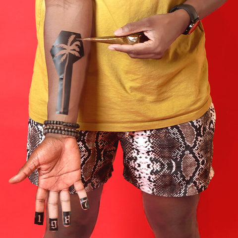 Man using a stencil to create henna tattoos