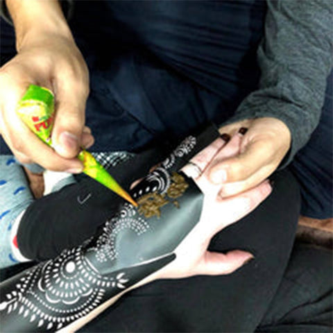 Apply henna paste onto henna stencil