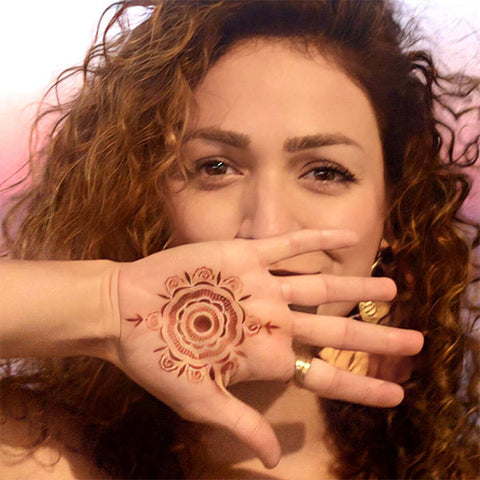 Woman with Camellia mandala henna tattoo on palm