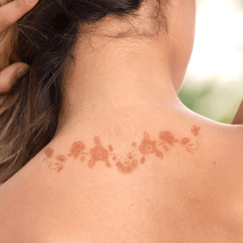 A photo displaying Azalea henna designs wrapped around a woman's neck.