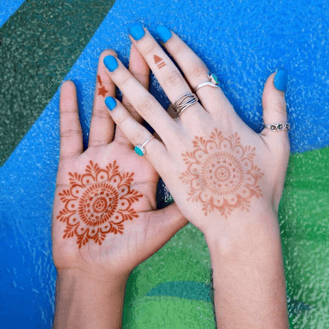 A woman displaying Haley henna tattoo at the front & back of her palms.