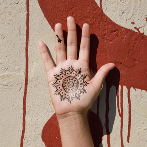 An image showcasing a dark-colored mandala jagua design on the right-hand palm.