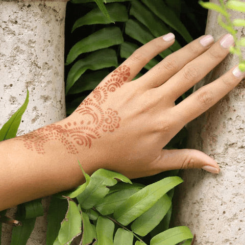 An image representing a woman’s left hand with Athena henna design at the back.