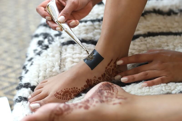 Create henna jewelry by applying henna paste to stencil
