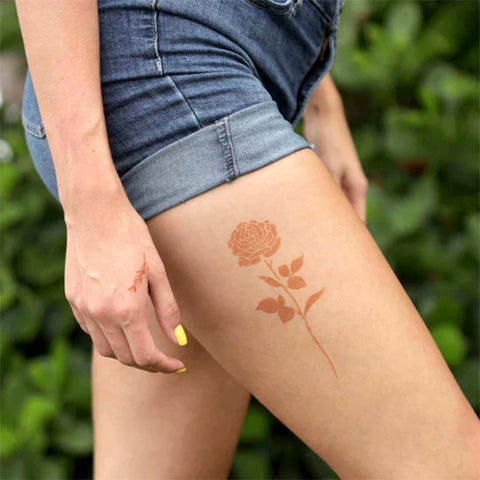 A woman showcasing the rose henna tattoo on her thigh that elevates her appearance.