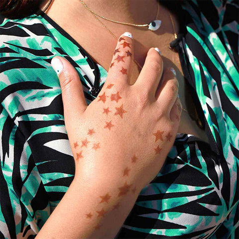 A woman showcasing her stellar henna stencil tattoo on her hand