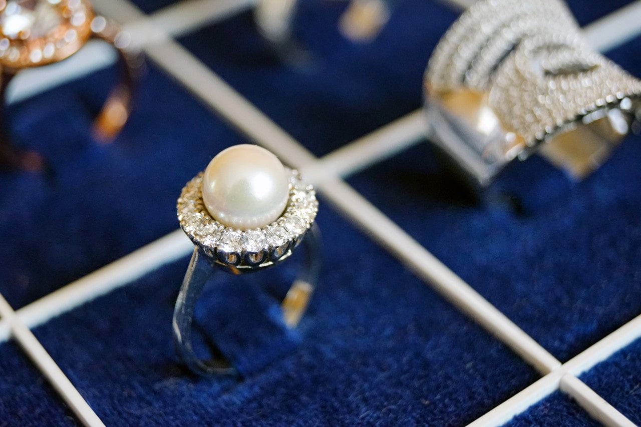 Fashion ring with pearl center stone surrounded by diamond halo setting.