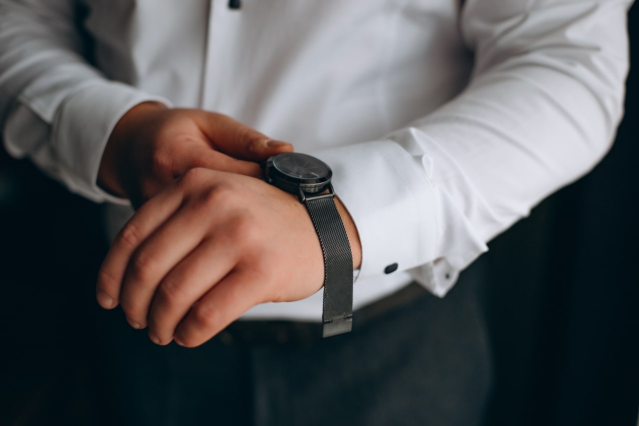 Man putting on watch in suit