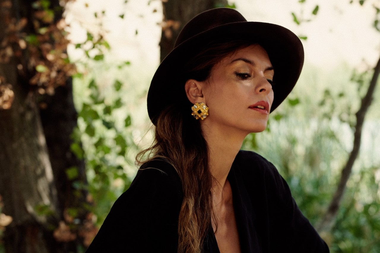 A woman wearing all black sports statement earrings on a walk.