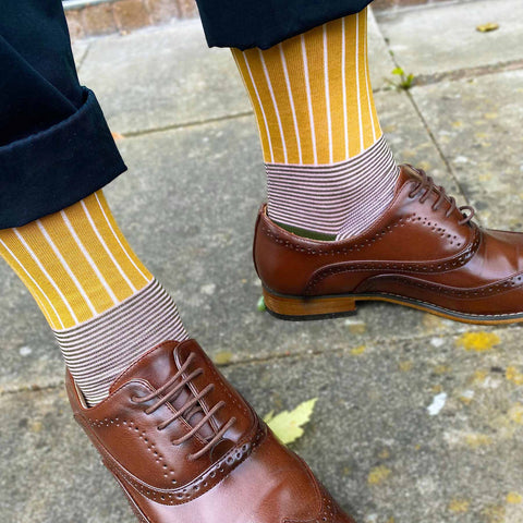 Man wearing smart black trousers and smart brown shoes with Peper Harow mustard Oxford Stripe luxury socks