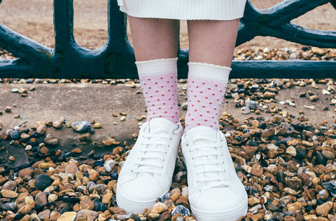 Woman wearing white skirt, white trainers and pink Pin Polka organic cotton women's socks